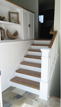 there is a set of stairs leading up to the second floor in this house with white painted walls