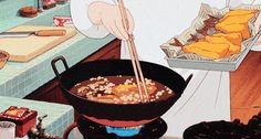 a person cooking food in a pan on top of a stove with chopsticks