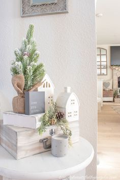 a stack of books sitting on top of a white table next to a christmas tree