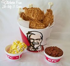 two buckets filled with fried chicken next to bowls of cornflakes and chili