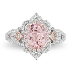 a pink diamond ring with diamonds around the band and an oval shaped center stone on top