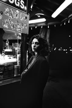 a woman standing in front of a food stand