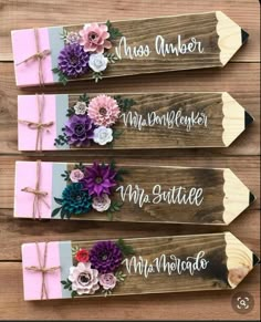 three wooden signs with flowers on them