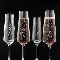 four wine glasses with the names of three different wines in them, all lined up against a black background