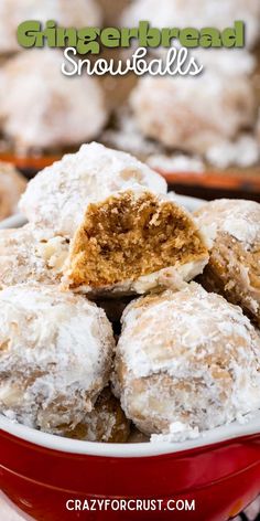 a red bowl filled with powdered sugar covered doughnuts on top of a table