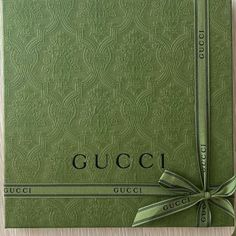 a green gucci book with a bow tied around it