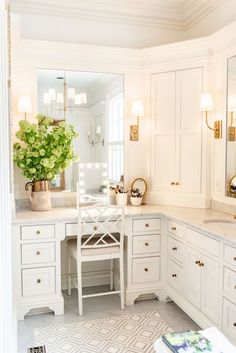 a bathroom with white cabinets and gold accents