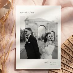 a wedding save the date card with an image of a man and woman in sunglasses