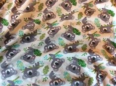 an animal print fabric with koalas and leaves on it's back ground