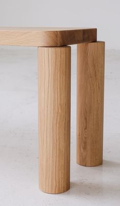 two wooden stools sitting next to each other on a white floor with no one around them