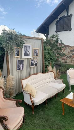 an outdoor living room with couches, chairs and pictures on the wall