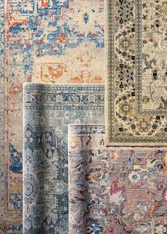 an assortment of rugs with different colors and patterns on the carpet, including blue, beige, red, green, orange