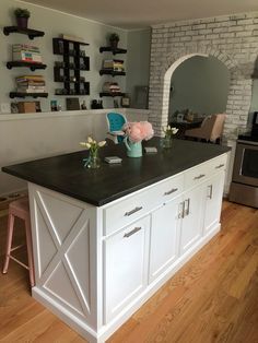 a kitchen island with two vases and flowers on it