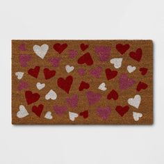 a brown door mat with red and white hearts on it