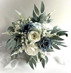 a bouquet of white and blue flowers with greenery