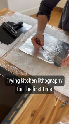 a person painting on a piece of paper with the words trying kitchen photography for the first time