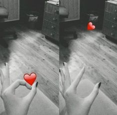 two hands holding up red hearts in front of a room with other furniture and appliances