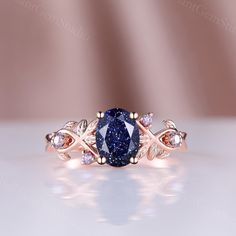 a ring with a blue stone surrounded by white and rose gold accents on a table