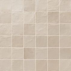 a white tiled wall with small squares on it