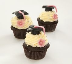 three chocolate cupcakes with white frosting and graduation caps