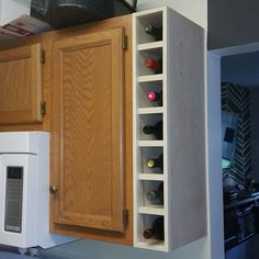 a kitchen with wooden cabinets and wine racks on the wall over the stove top oven