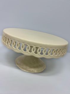 a white cake plate sitting on top of a table