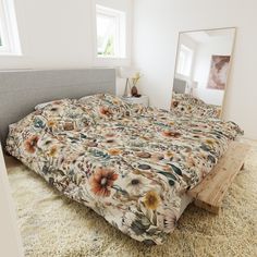 a bed with a floral comforter on top of it