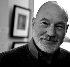 black and white photograph of an older man smiling at the camera with his eyes closed