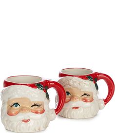 two red and white santa mugs sitting next to each other