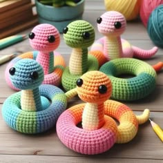 crocheted toys are sitting on a table with markers and pencils next to them