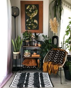 a living room with plants and rugs on the floor, potted plants in front of a painting