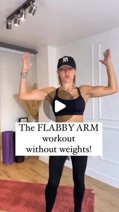 a woman standing on top of a yoga mat with her arms in the air