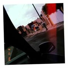 the view from inside a car looking out at an empty street with buildings in the background