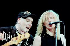 two people on stage playing guitars and singing