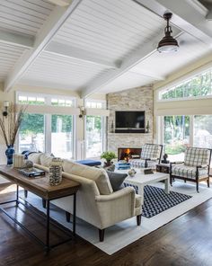 a living room filled with furniture and a flat screen tv mounted on the wall above a fireplace