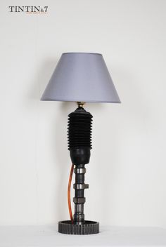 a lamp that is sitting on top of a white table next to a light blue shade