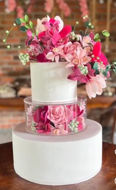 three tiered wedding cake with pink flowers on top