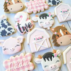 decorated cookies with farm animals and the word time are on a white wooden table top