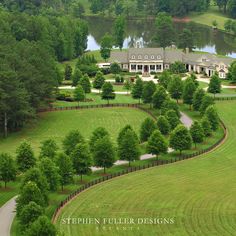 an aerial view of a large house in the middle of a lush green field with trees