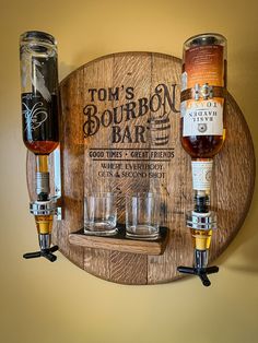 a wooden sign with three glasses on it and a bottle of bourbon in the bottom