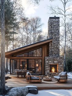 a log cabin with a fireplace and seating area in the snow covered ground next to trees