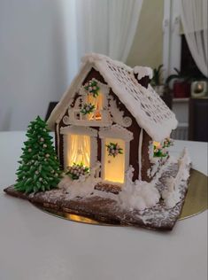 a gingerbread house is decorated with christmas lights and snow on the roof for decoration