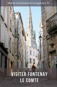 an alley way with buildings and a person walking down the street in front of it