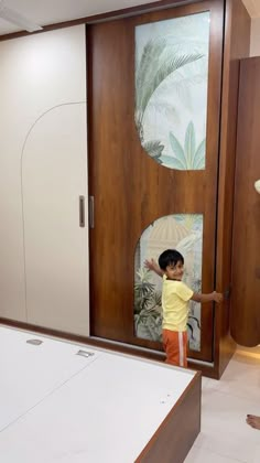 a little boy standing in front of a wooden door