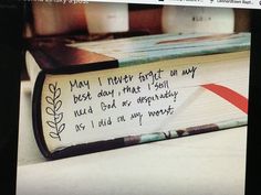 an open book with writing on it sitting on a table next to candles and other items