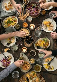 a group of people sitting around a table eating food