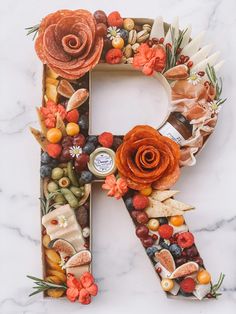 the letter r is made up of fruits, nuts, and other things to make it look like a flower