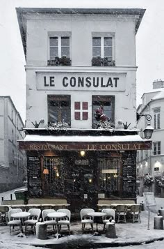 an outdoor cafe with tables and chairs covered in snow