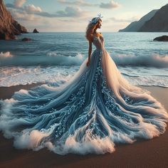 a woman in a blue and white dress standing on the beach with waves crashing around her