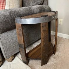 a wooden table sitting on top of a carpeted floor next to a gray couch